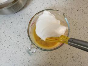 取三分之一蛋白霜加入蛋黄面糊拌匀，将蛋黄糊倒回蛋白霜盆，用切拌或者翻拌的手法混合，然后将混合好的蛋糕面糊倒入蛋糕模内，震去模具内的空气