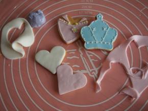 用模具切割翻糖皮，对应饼干放上，可以用一点翻糖膏融化于水作为粘合剂，表面的装饰细条我是用糖霜装在裱花袋里挤的，也可以用翻糖膏做各种立体造型，尽情发挥吧