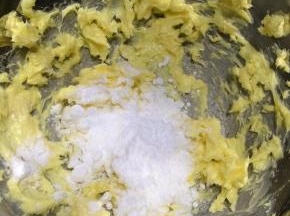 用电动打蛋器将黄油打散后，加入糖粉。