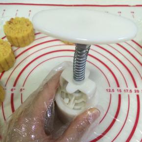 按下月饼模具，压制出绿豆糕的形状。