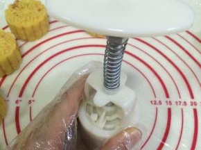 按下月饼模具，压制出绿豆糕的形状。