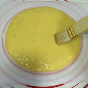 铺上第二块面饼，周围压实了，表面刷上鸡蛋液。