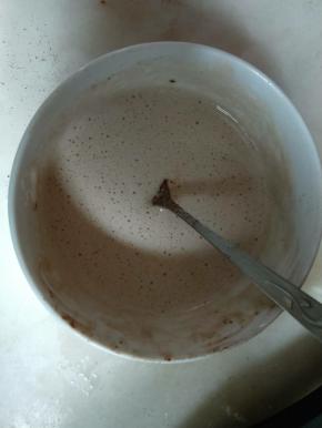 在牛奶液中加入可可粉和泡软的吉利丁片隔水加热搅拌至完全融化，装入裱花袋进行淋面。