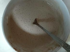 在牛奶液中加入可可粉和泡软的吉利丁片隔水加热搅拌至完全融化，装入裱花袋进行淋面。
