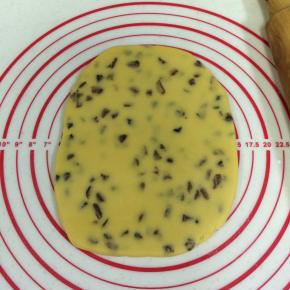 把面团放在案板上压扁，用擀面杖擀成厚约0.8厘米的面片。