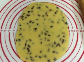 把面团放在案板上压扁，用擀面杖擀成厚约0.8厘米的面片。