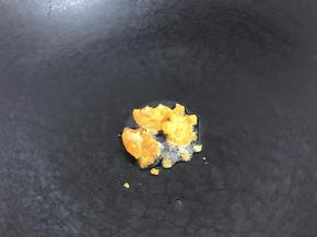 3、油锅下咸蛋黄碎炒到出沙。