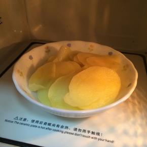 土豆削皮切薄片，入微波炉烤约12分钟至熟。