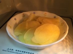 土豆削皮切薄片，入微波炉烤约12分钟至熟。
