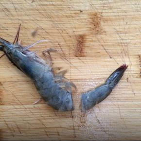 把虾清洗干净，沥干水分，在虾尾2-3厘米处切断。