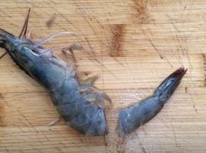 把虾清洗干净，沥干水分，在虾尾2-3厘米处切断。