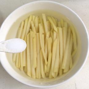 把马铃薯条过水清洗几遍，然后浸泡在清水中，加入少许盐，浸泡10分钟即可！