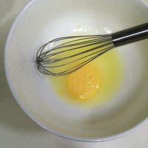 在盆内加入色拉油、猪油和鸡蛋液，用手动打蛋器搅拌均匀。