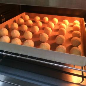 入预热好的烤箱中层，上下火，165度，25分钟左右，观察下椰蓉球上色情况，以免烤过了。