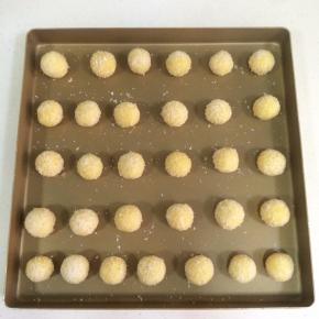 把做好的椰蓉球摆入不粘烤盘内，椰蓉球之间要留有空隙，如果不是不粘盘记得垫张油纸。