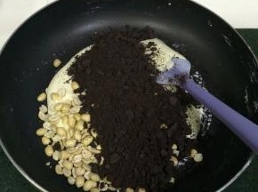 关火，加入花生和奥利奥饼干碎，迅速翻拌均匀，用手摸着干而不粘手即可。