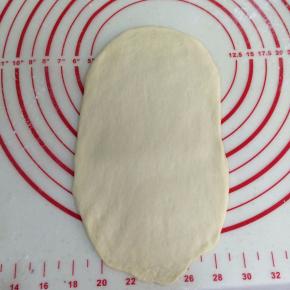 取一个松弛好的面团，擀成椭圆形的面片。