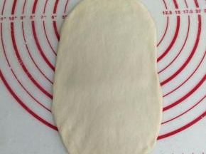 取一个松弛好的面团，擀成椭圆形的面片。