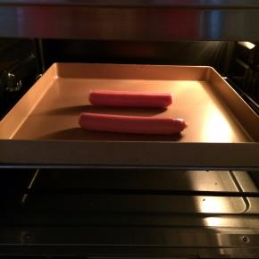 取2根香肠，入烤箱210烤约7分钟。