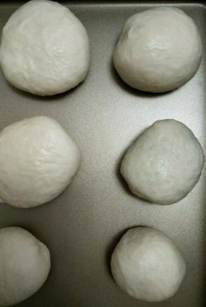 放入烤盘中进行二发，旁边放盆水，二发40分钟左右，发至二倍大取出刷蛋液，表面筛上少许面粉。预热烤箱，180度烤18分钟即可。