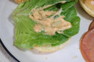 下面一层面包放上一片生菜叶，抹上一层千岛酱