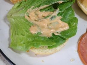 下面一层面包放上一片生菜叶，抹上一层千岛酱