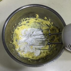 加入糖粉，用打蛋器搅拌均匀。（先用打蛋器稍微搅动下，以免搅打的时候飞溅起来。）