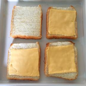 烤盘底部先刷有一层植物油（烤出来吐司底才香脆哦），然后每一片吐司上放一片芝士 （你们可能好奇为啥有一片吐司没放，因为我家小三娃跟我说他不要芝士片）