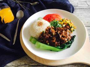 盛上一人份的酱烧茄子，再搭配一杯鲜橙汁。