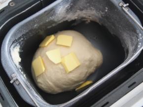 加入牛奶（不要一次加入哦，请根据面团的软硬程度稍作调整），开启揉面程序，揉成光滑面团后加入黄油，继续揉至出膜