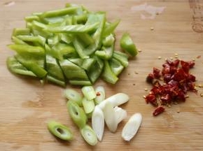 青椒去籽切块，葱切末，姜切末，红辣椒也切末。