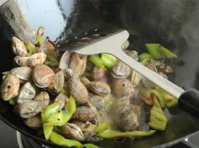 下入蛤蜊继续翻炒，会看到产生大量的烟，火力够猛。