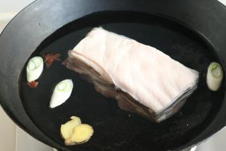 带皮五花肉，整块冷水入锅，加葱段、姜片和八角，煮开后煮25分钟至熟透。