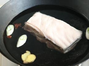 带皮五花肉，整块冷水入锅，加葱段、姜片和八角，煮开后煮25分钟至熟透。