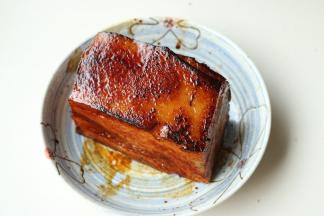 肉皮煎到焦黄起泡的程度，移到盘子里晾凉。接下来先炒香梅干菜。