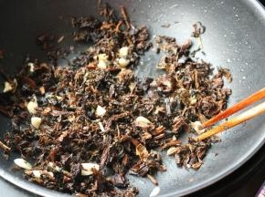 加入梅干菜，炒到水分变少。