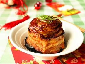 盘子扣在碗上，快速翻转，把扣肉倒扣在盘子里，表面撒葱丝装饰。好吃的富贵扣肉就做好了。