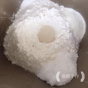 面包机内先加入液体，清水、鸡蛋液，再加入高粉、奶粉，糖和盐要对角放。在面粉中间放入酵母。