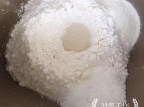 面包机内先加入液体，清水、鸡蛋液，再加入高粉、奶粉，糖和盐要对角放。在面粉中间放入酵母。