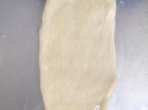 取一个面团从中间开始分别向上下两个方向将面团擀成长舌状，约长20cm左右。用手把边缘的气泡压出来。