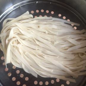 撒少许干粉，将面片折叠起来，均匀地切成细条。