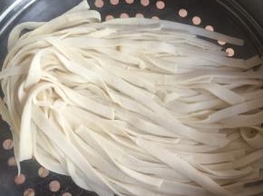 撒少许干粉，将面片折叠起来，均匀地切成细条。