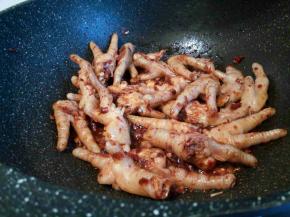 放入花椒也炒香，再下焯好水的凤爪翻炒一下，