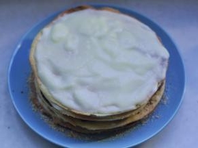16、 取一张饼皮，在上面均匀抹上奶油    