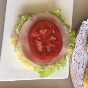 底部面包上放上一片生菜叶，抹上沙拉酱，放一片即食美式火腿片，放上一片番茄