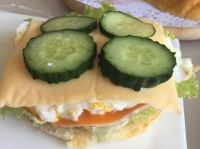 鸡蛋上铺上一片香浓原味芝士片，再放上四片黄瓜