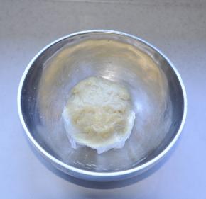 4、然后将面搅拌均匀揉成团，用保鲜膜包住，静置15分钟。