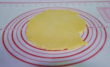 5、用擀面杖，把面团擀成0.3厘米的面片，打开烤箱预热。