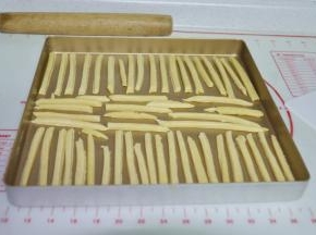 6、用刀把面片切成正方形的长条，摆入烤盘里。