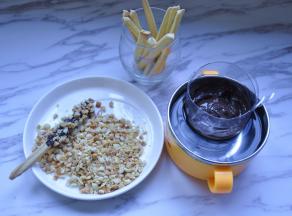 8、用水浴法将巧克力融化，依次淋在牛乳棒上，然后沾上烤熟的花生碎即可。